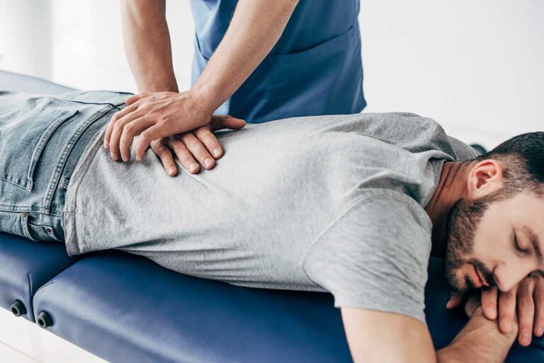 A person receiving a gentle spinal adjustment from a chiropractor in a clinical setting.